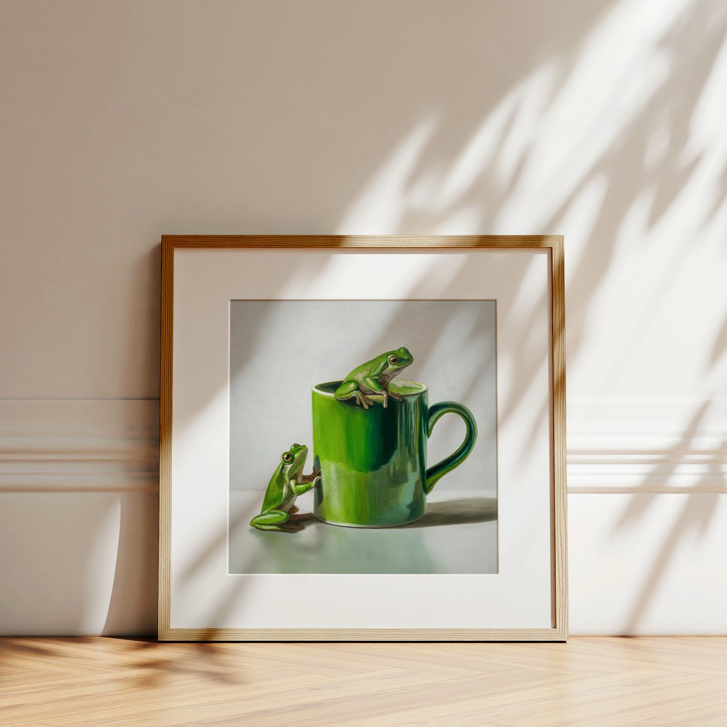 Green Frogs & Cup Fine Art Print by Lauren Pretorius: a green frog on a green mug against a light gray background