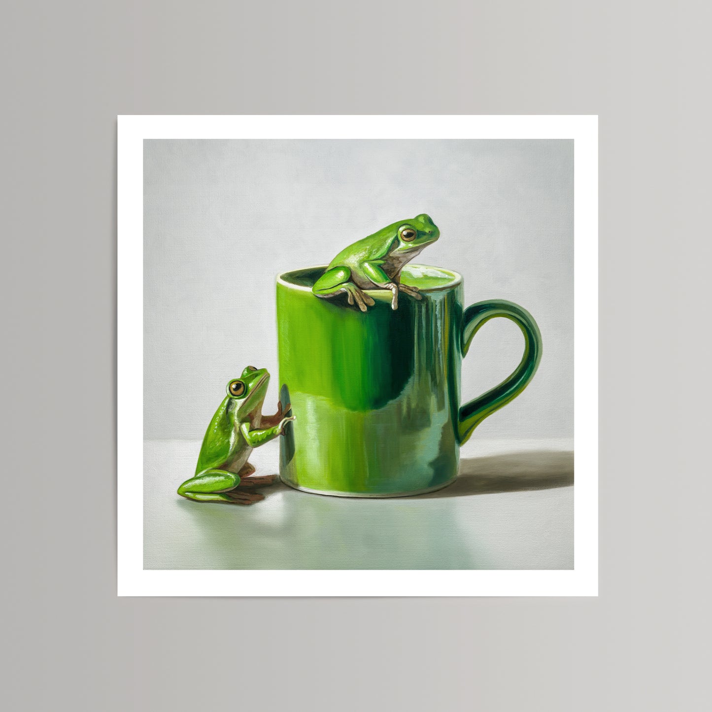 Vibrant green frogs on and beside a glossy green ceramic mug, fine art print on cotton rag paper.
