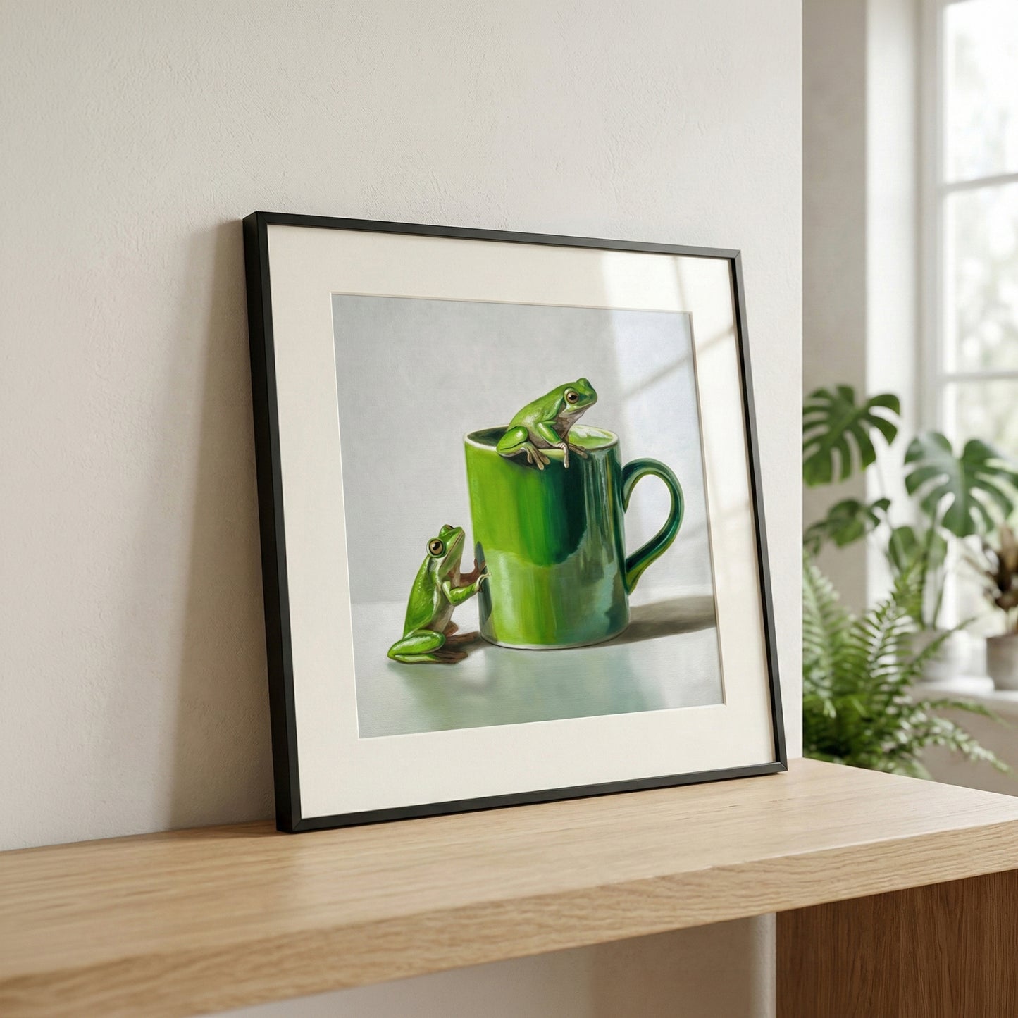 Framed fine art print of two vibrant green tree frogs with a matching green mug on a light background.