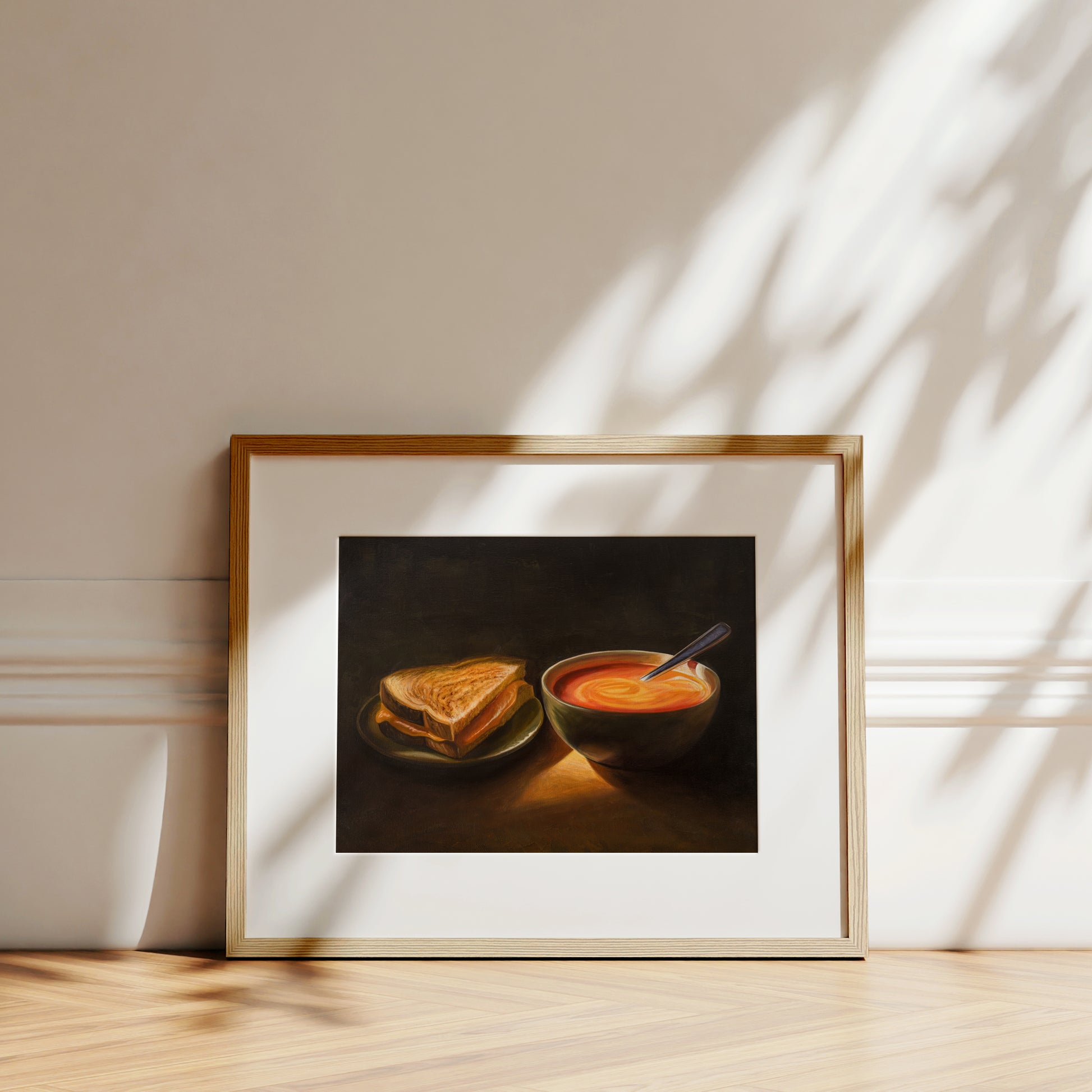 Grilled Cheese & Tomato Soup Fine Art Print by Lauren Pretorius: a bowl of tomato soup and a grilled cheese sandwich, with a spoon resting in the soup.