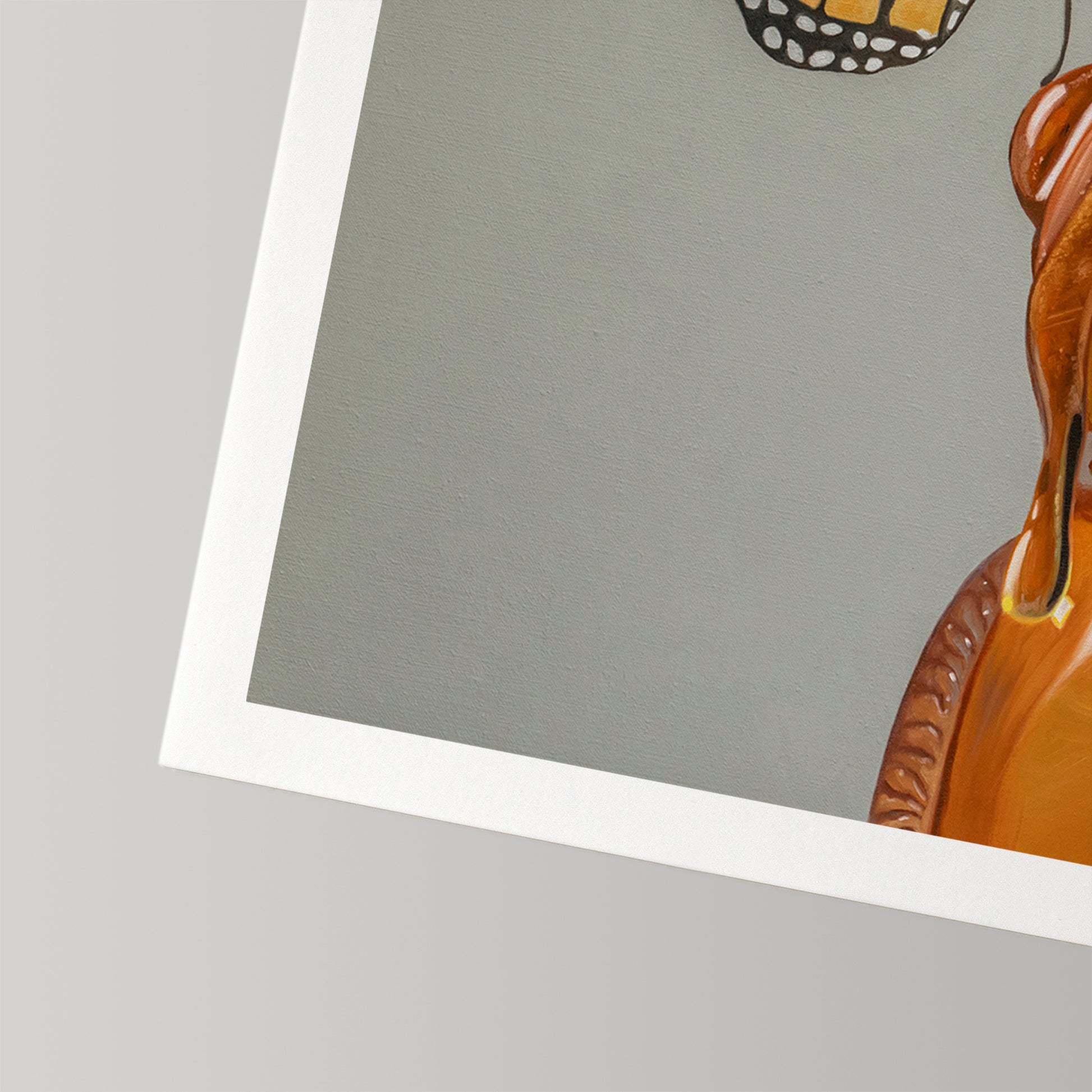 Close-up of a fine art print featuring a honey bear and monarch butterfly on cotton rag paper with a white border.