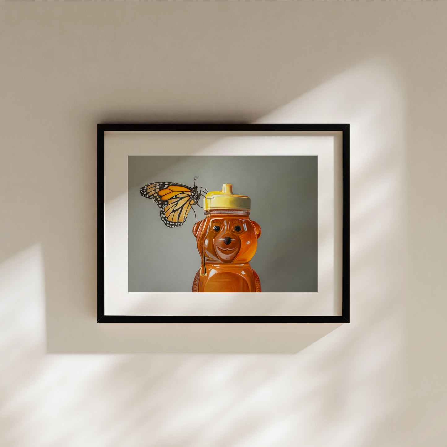 Framed fine art print of a monarch butterfly perched on a honey bear bottle.