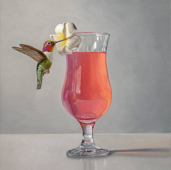 Glass of pink drink with a white flower and a hummingbird on a gray background