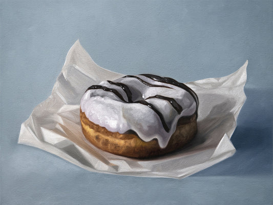 Iced Donut Fine Art Print by Lauren Pretorius: a single iced donut resting on a piece of crumpled wax paper resting on a light blue surface.