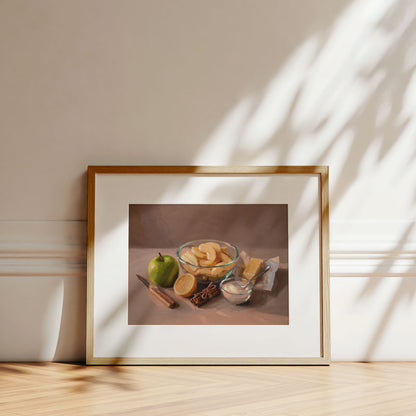 Oil painting print of apple pie ingredients in a wooden frame on a floor with soft sunlight shadows.