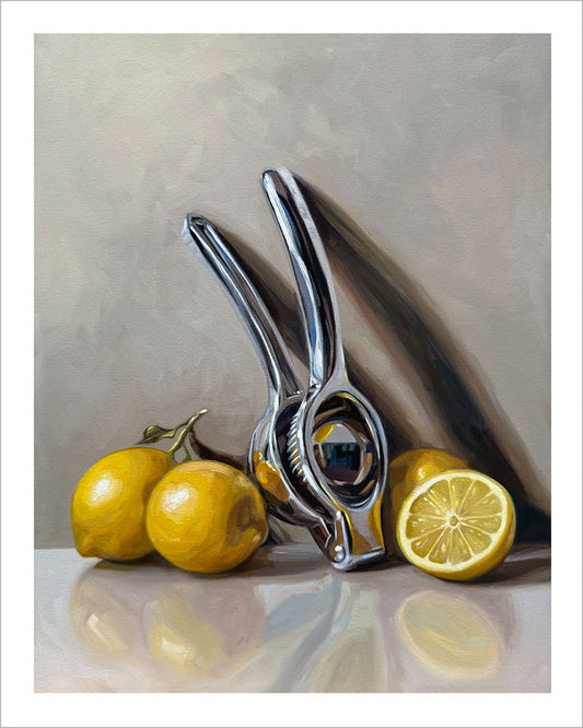 Fine art print of a shiny metal citrus press with bright yellow lemons on a neutral background with a white border.
