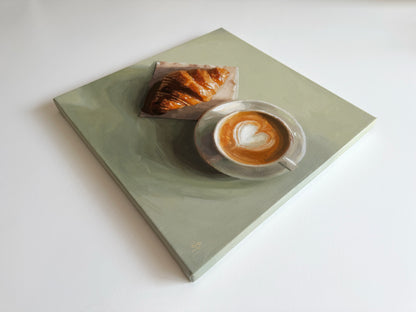 An oil painting on canvas depicting a light sage green square table with a croissant and a cup of latte art coffee, shown from an elevated perspective on a white background.