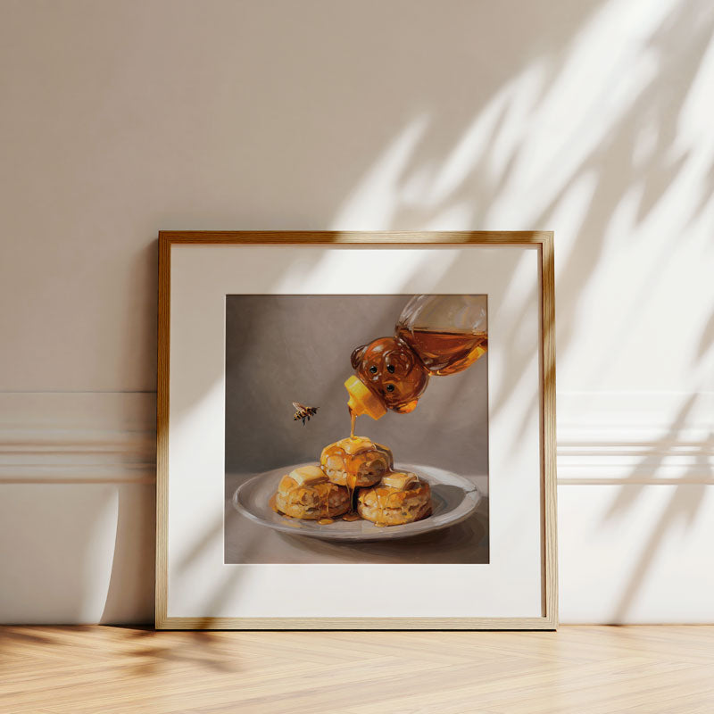 Framed fine art print of honey being poured over buttered biscuits with a bee, on museum-grade cotton rag paper.