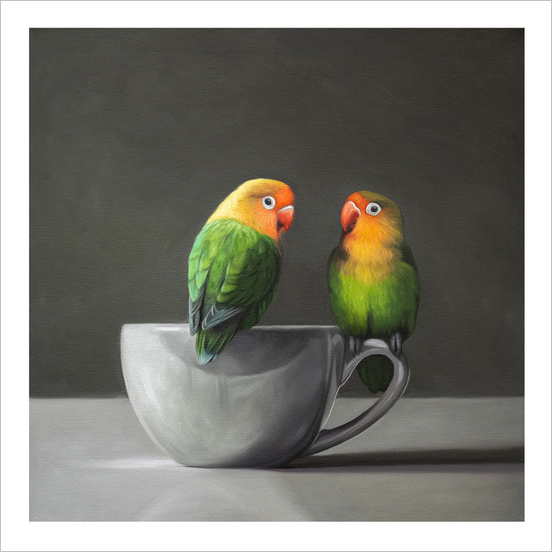 Fine art print of two colorful lovebirds perched on a white porcelain teacup against a dark grey background.