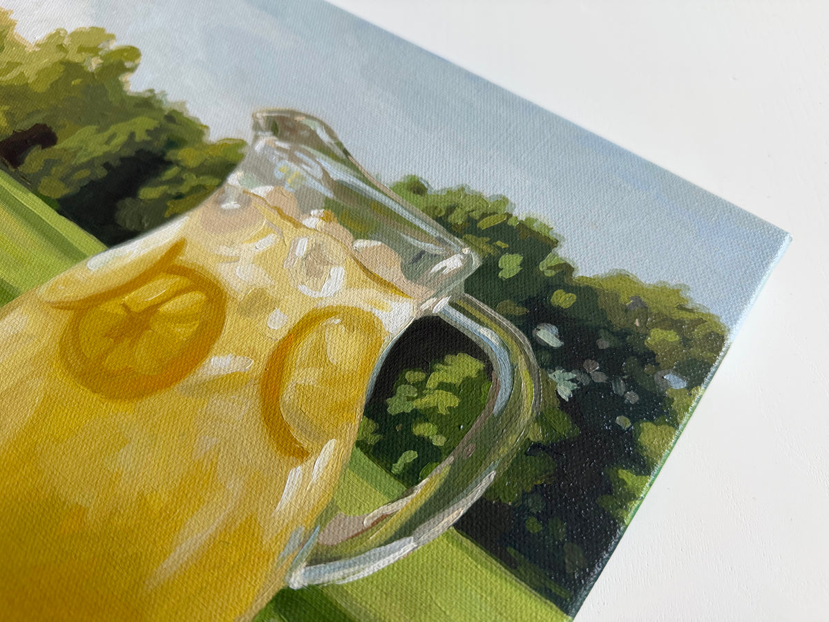 14x11 oil painting on canvas featuring a glass pitcher of yellow lemonade against a lush green summer yard.