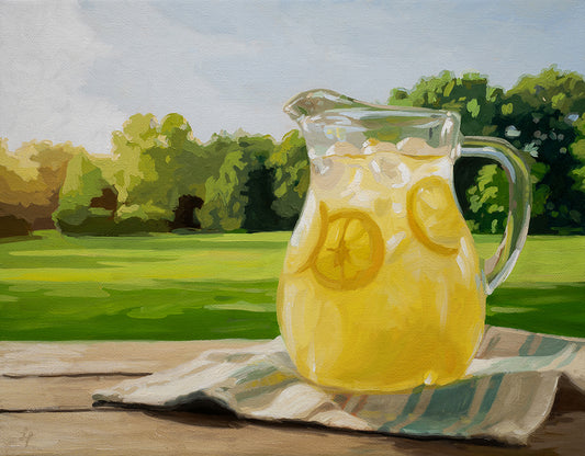 14x11 original oil painting of a glass pitcher of lemonade on a wooden table against a lush green summer landscape.