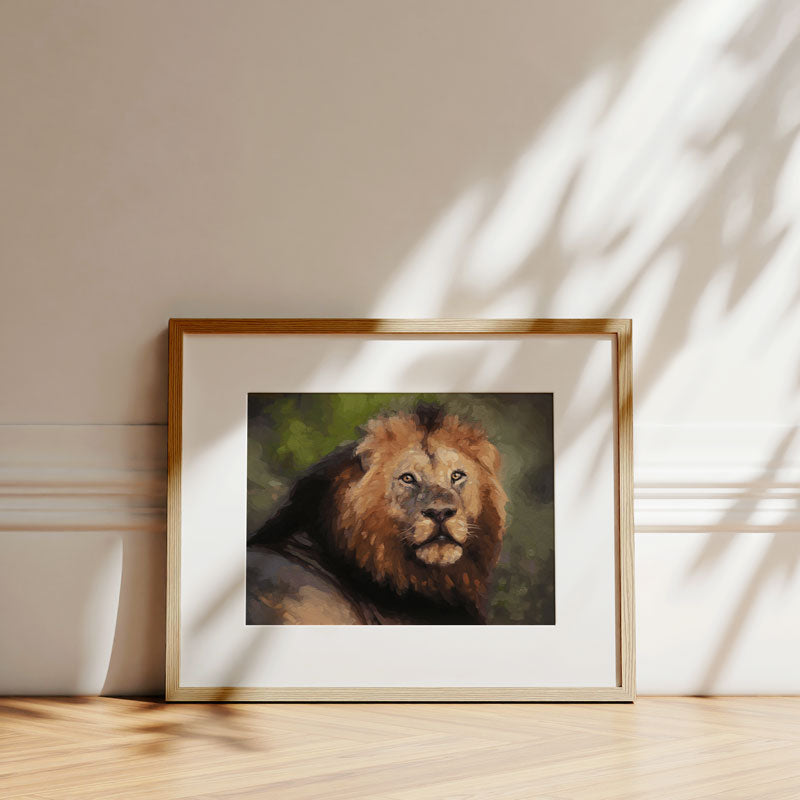 Fine art print of a South Shishangeni male lion in a light wood frame, resting against a wall with soft leaf shadows.