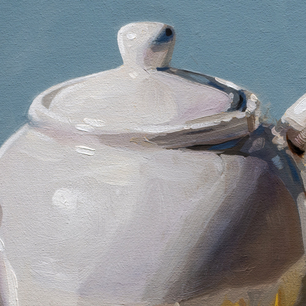 Close-up of a ceramic teapot with a lid on a blue background
