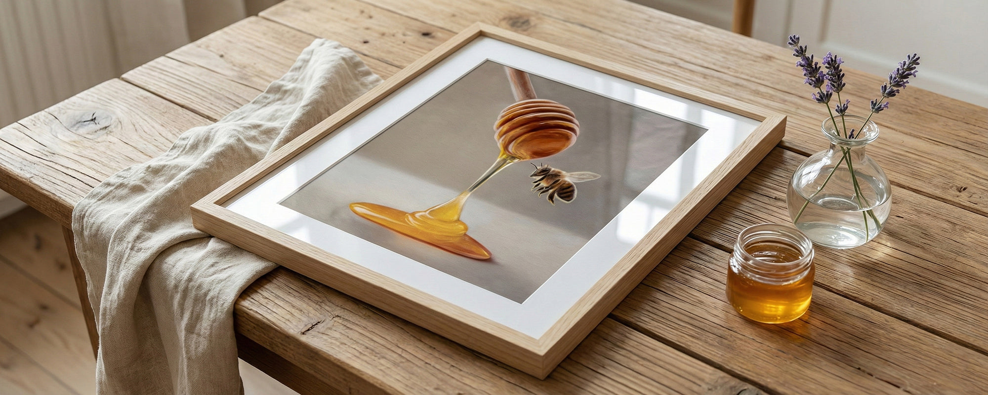 Framed picture of a honey dipper by Lauren Pretorius on a wooden table with a jar of honey and lavender flowers.