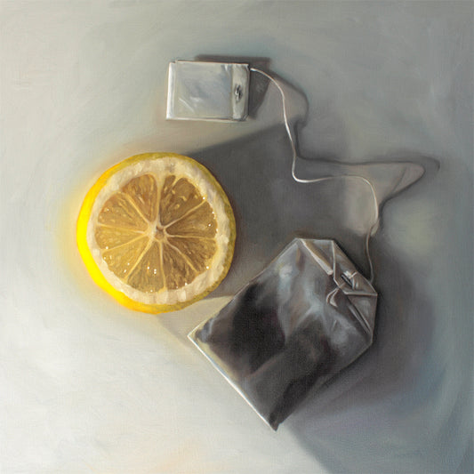 Lemon Slice and Tea Bag Fine Art Print by Lauren Pretorius: a slice of lemon laying next to a tea bag on a light grey surface with dramatic lighting and cast shadows.