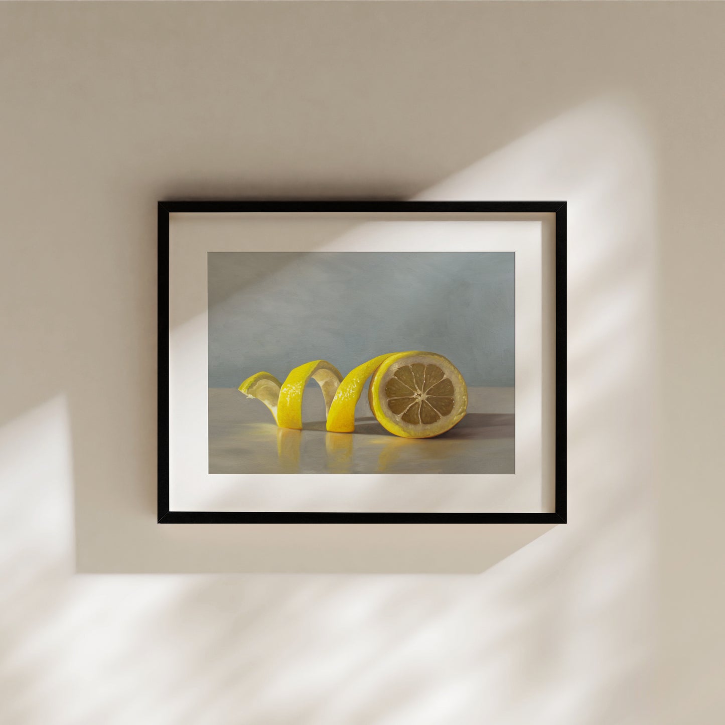 Lemon Twist Fine Art Print by Lauren Pretorius: a lemon half with its peeling spiraling out towards the left on a light, reflective surface and muted blue background.
