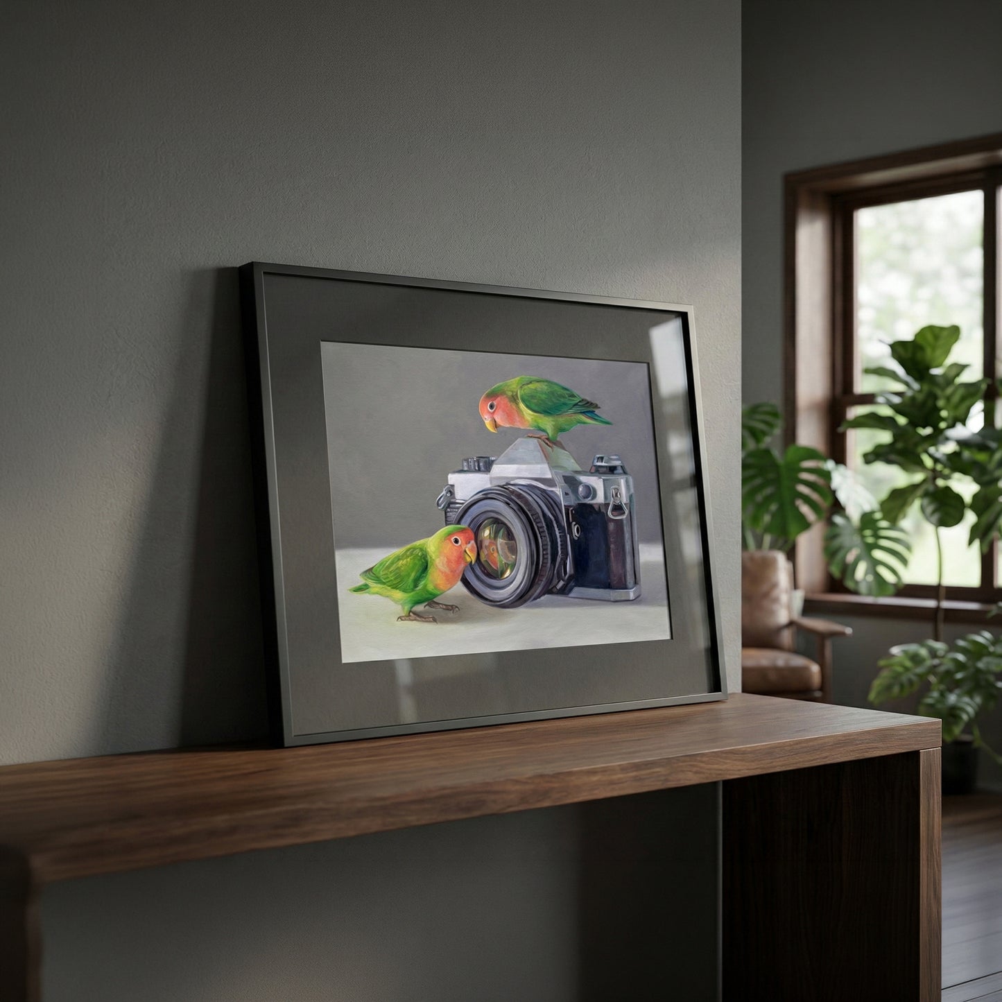 Framed fine art print of two colorful lovebirds perched on a vintage camera, displayed on a wooden console.