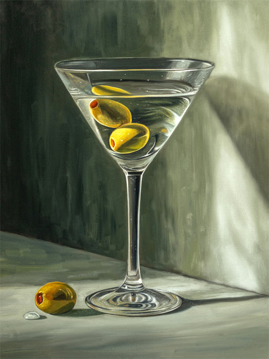 Martini & Olives Fine Art Print by Lauren Pretorius: a martini glass with olives, depicted with soft lighting and a shadow on the wall.