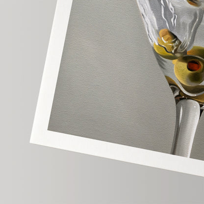 Close-up of a Martini Splash fine art print on cotton rag paper, showing a glass with green olives.