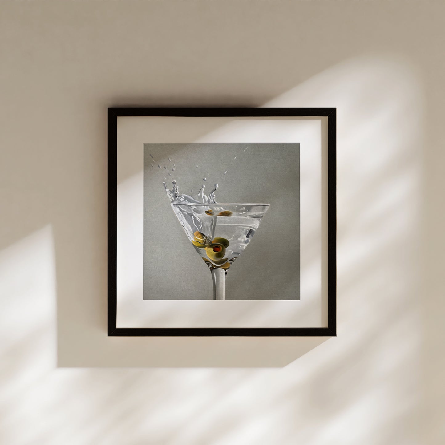 Martini Splash fine art print in a black frame, featuring a martini glass with olives and a splash.