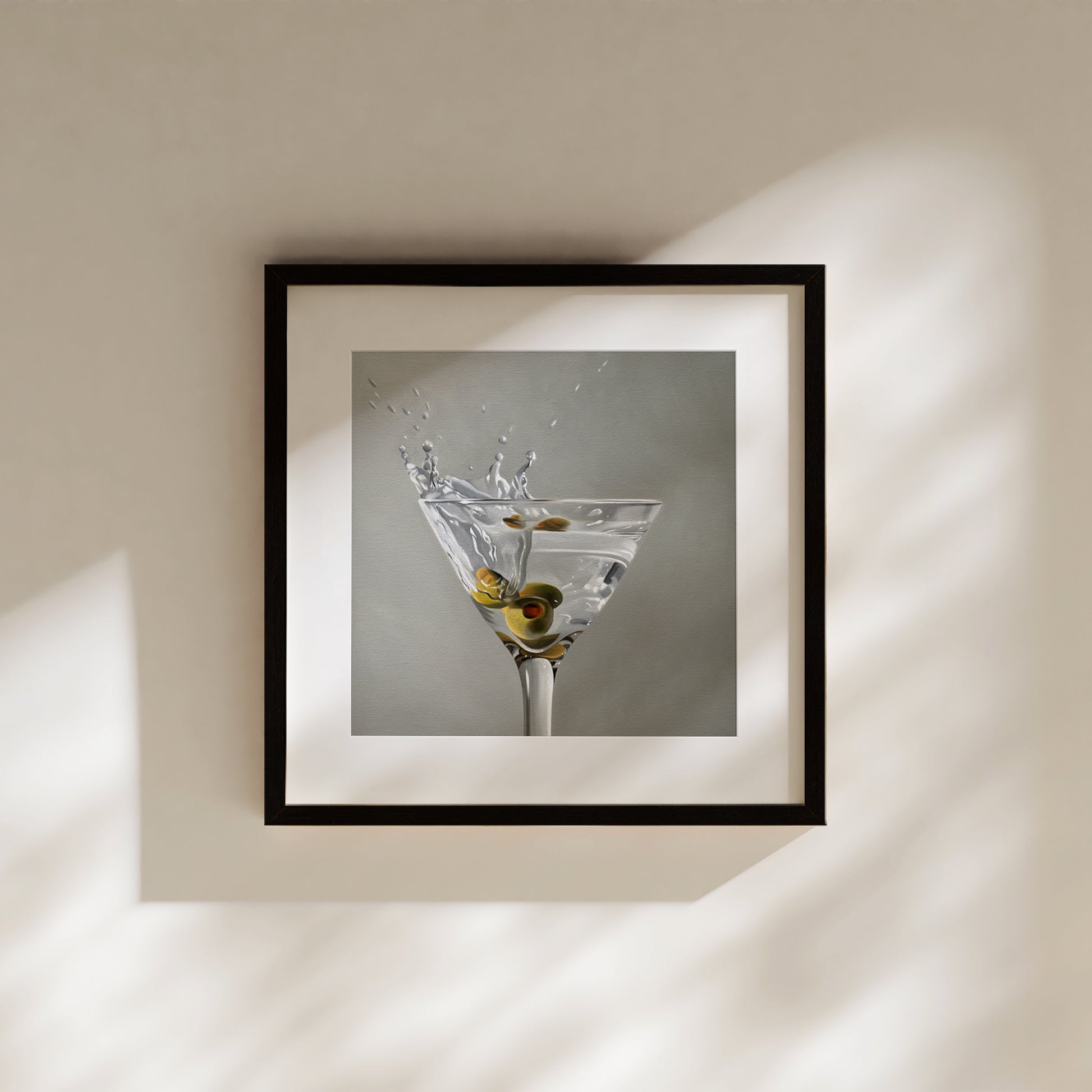 Martini Splash fine art print in a black frame, featuring a martini glass with olives and a splash.