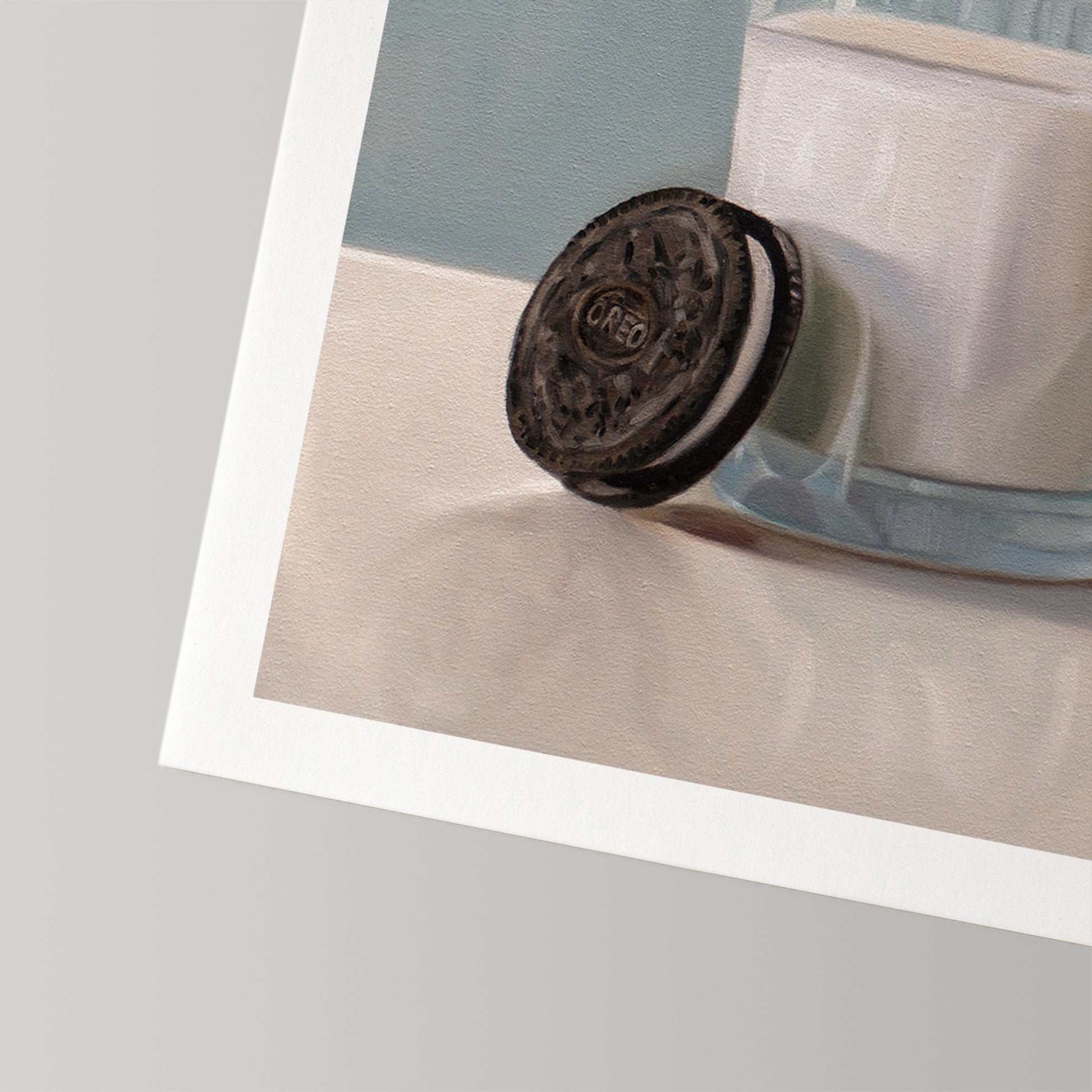 Fine art print of an Oreo cookie leaning against a glass of milk, with a white border.