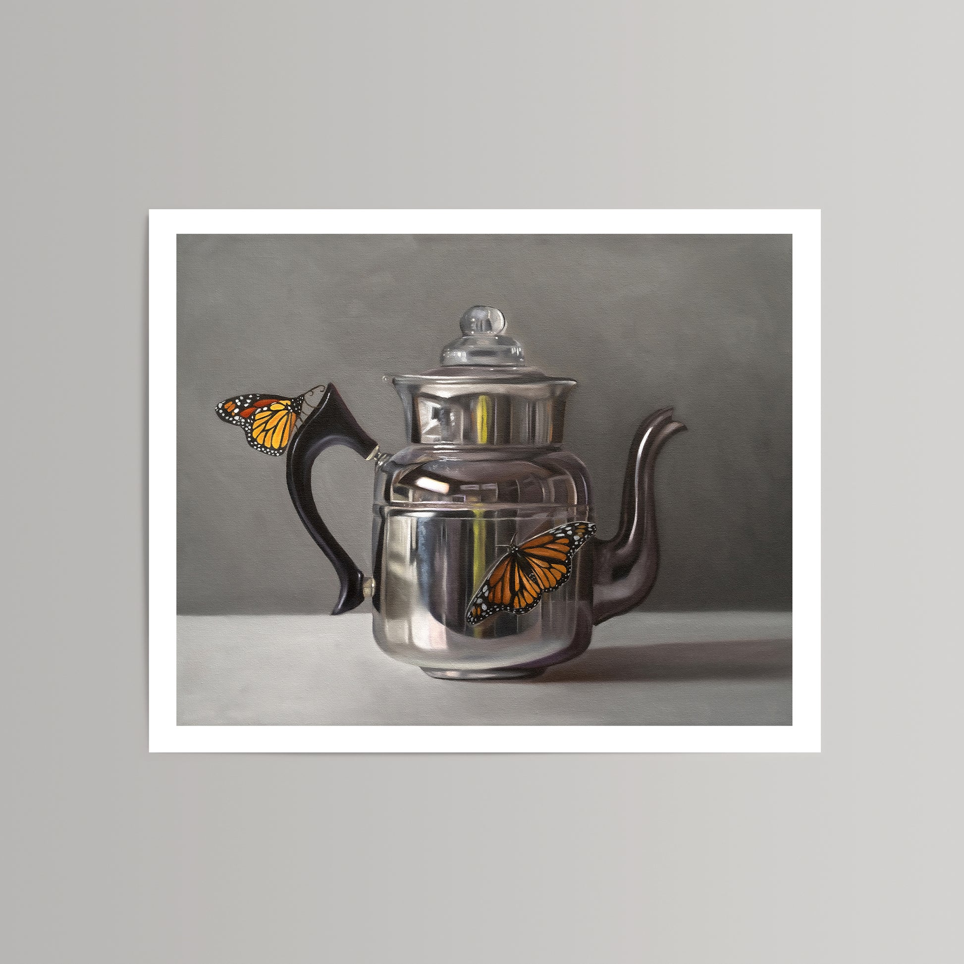 Fine art print of two vibrant orange monarch butterflies on a reflective silver kettle with a black handle.
