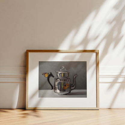 Fine art print of a silver kettle with two orange monarch butterflies, framed in light wood.