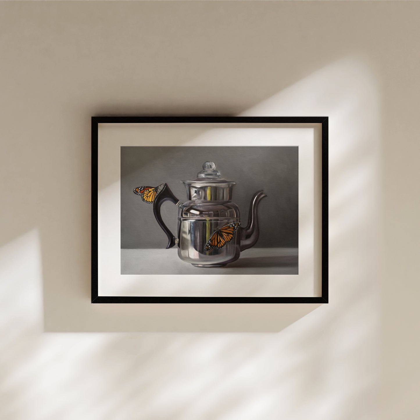 Framed fine art print of a metallic silver kettle with two vibrant orange monarch butterflies.