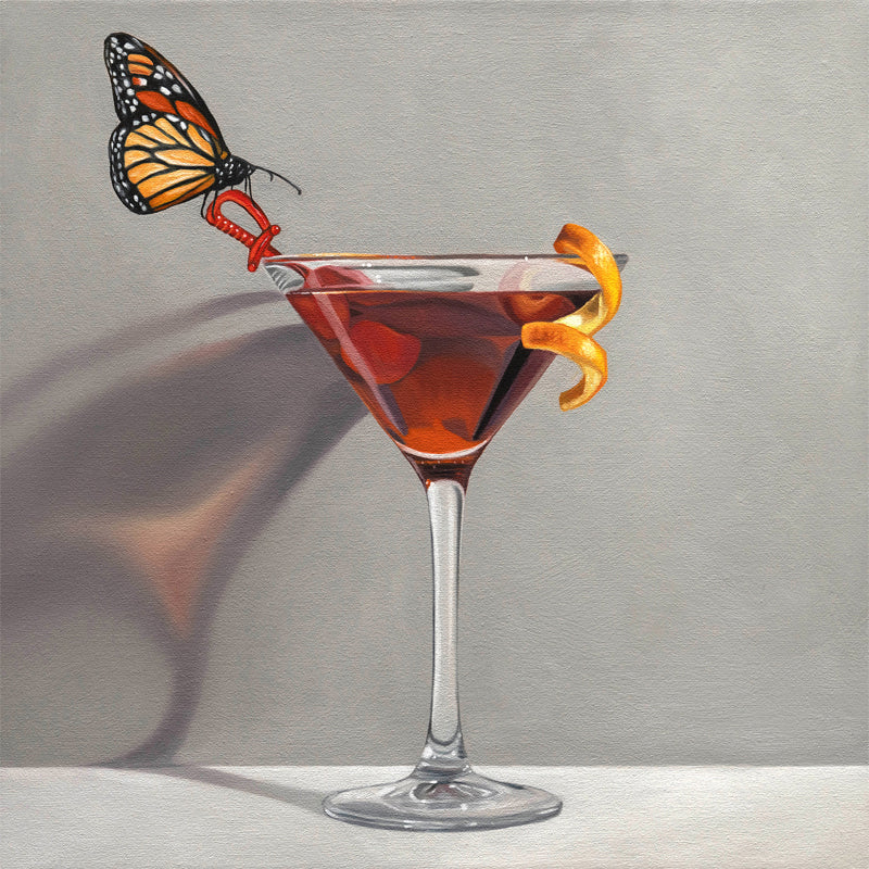 Vibrant Monarch butterfly on a red swizzle stick in a martini glass with a dark drink and orange peel.