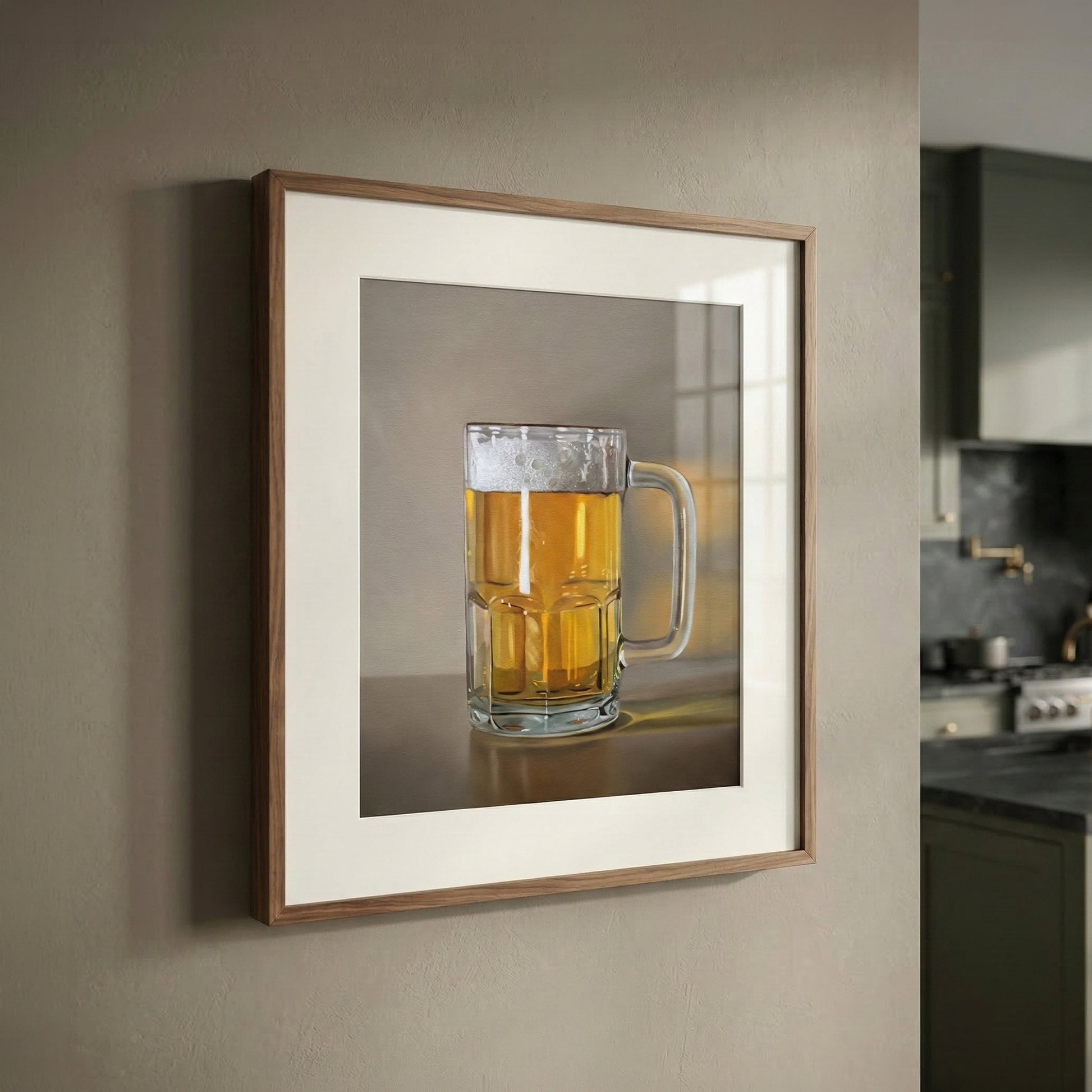 Framed fine art print of a frothy mug of golden beer, matted in a modern kitchen setting.