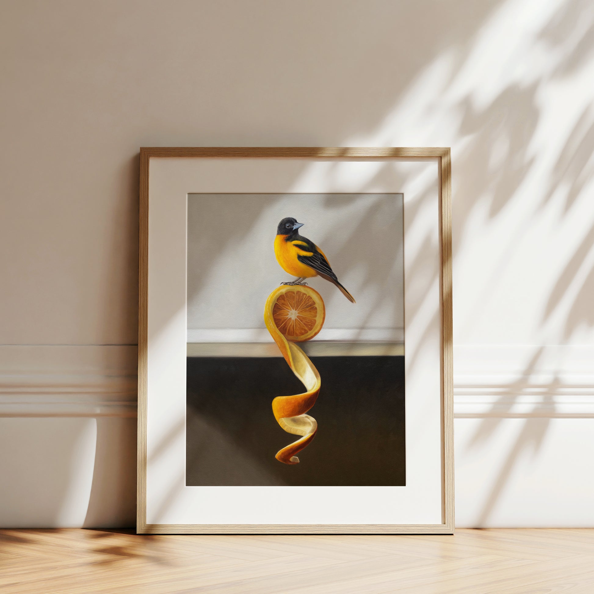 Framed fine art print of an orange and black oriole perched on a twisted orange peel.