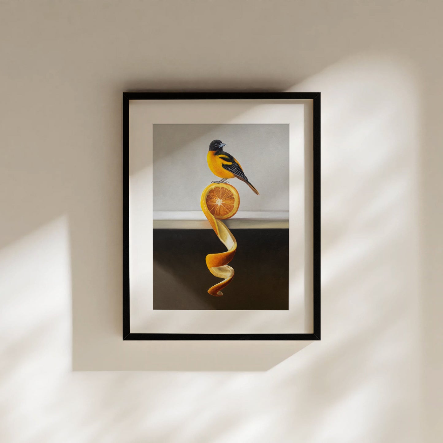 Framed fine art print of an orange and black oriole perched on a vibrant orange peel twist.
