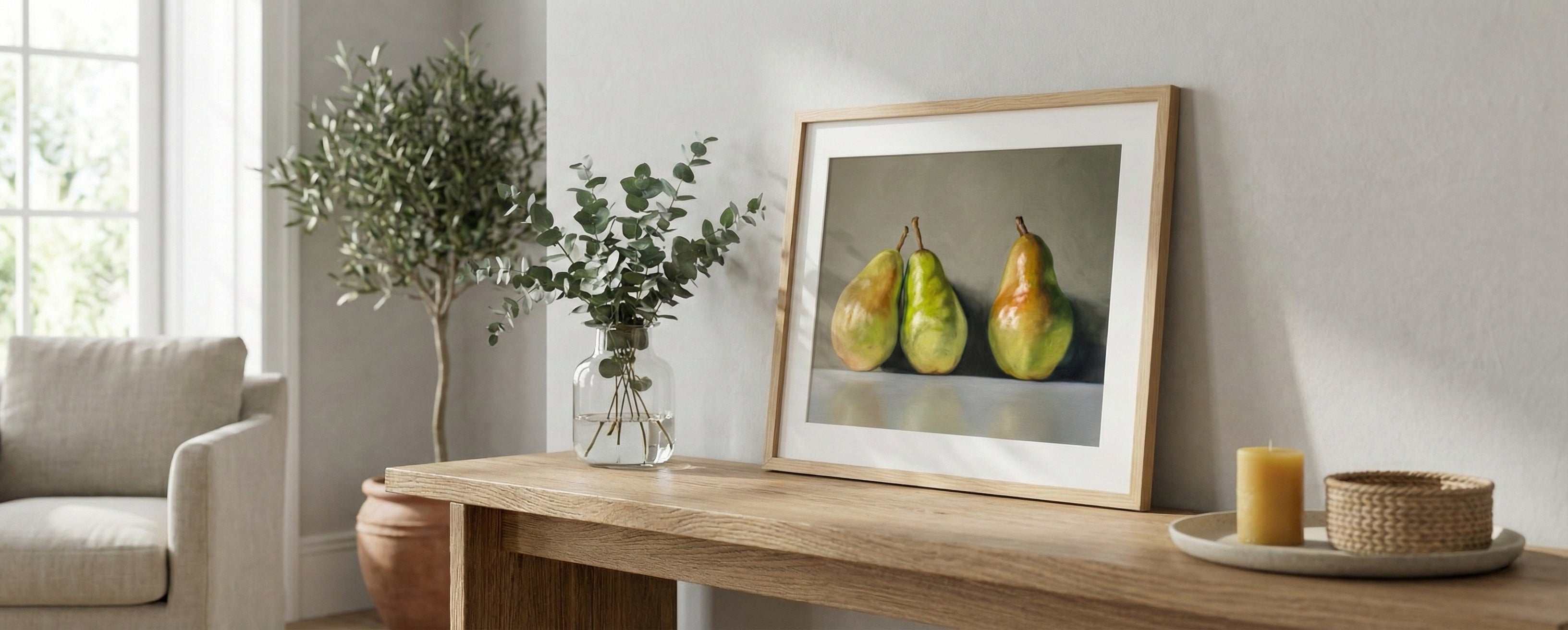 Framed artwork of pears on a wooden console table in a living room.