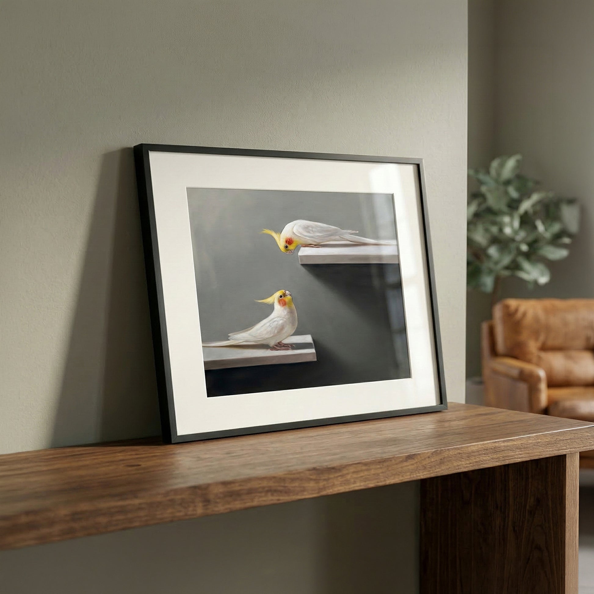 Framed fine art print of two white and yellow cockatiels on shelves, displayed on a wooden surface.