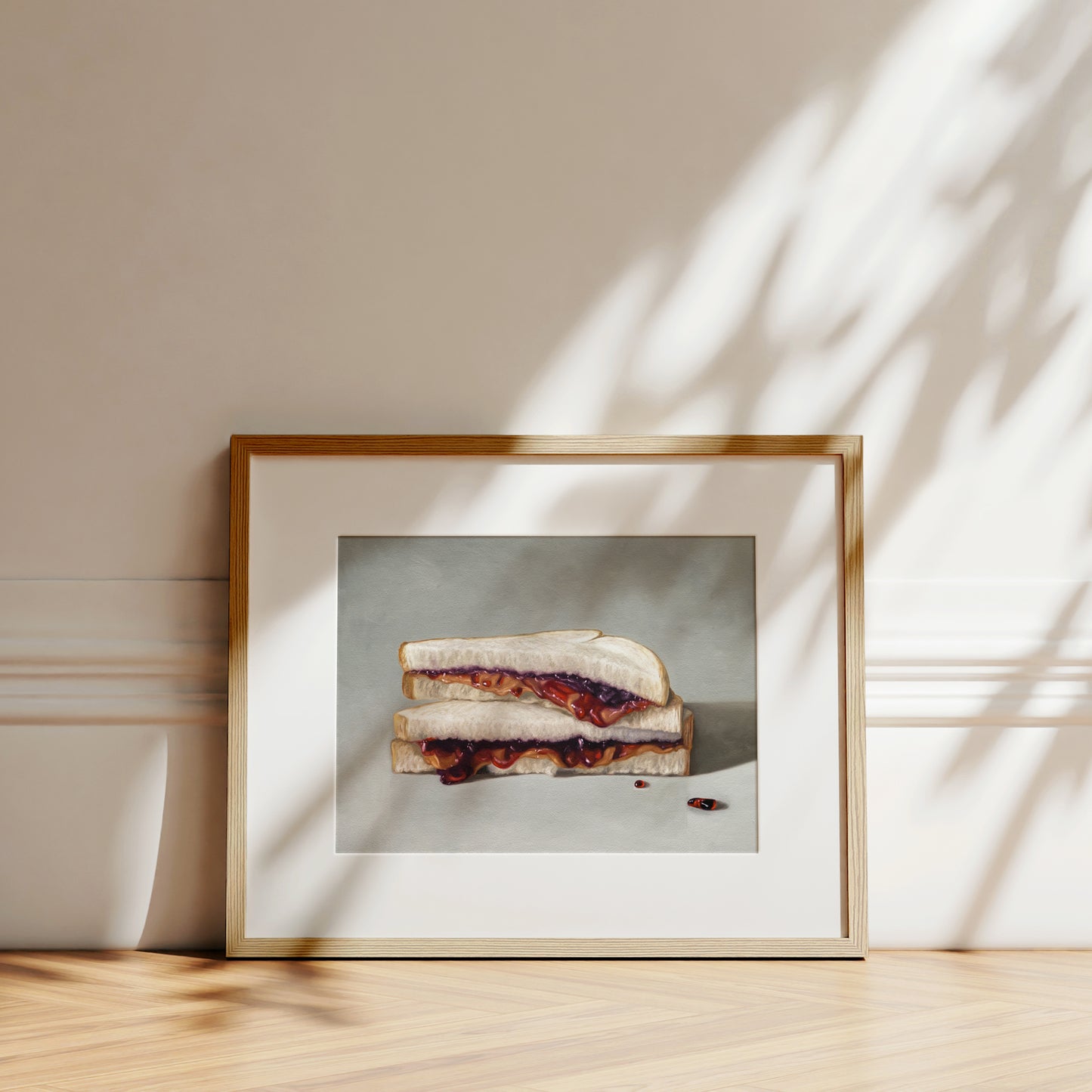 Framed fine art print of a realistic peanut butter and jelly sandwich on white bread.