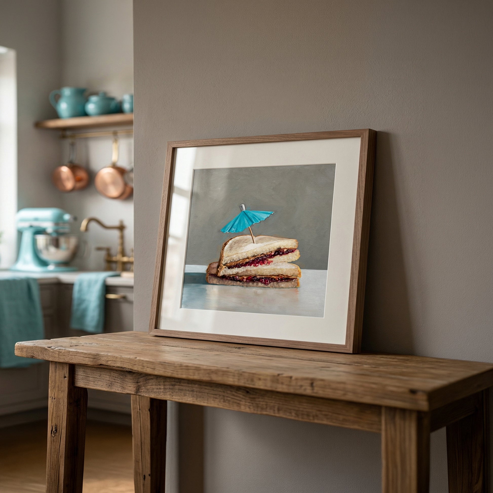 Framed art print of a peanut butter and jelly sandwich with a blue cocktail umbrella on a rustic wooden table.