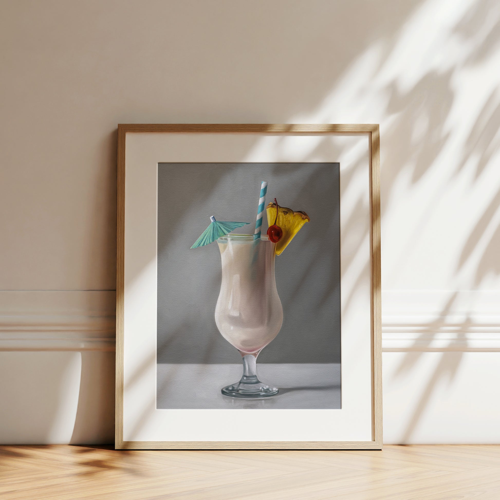 Framed fine art print of a creamy Piña Colada cocktail with a pineapple slice, cherry, blue straw, and umbrella.