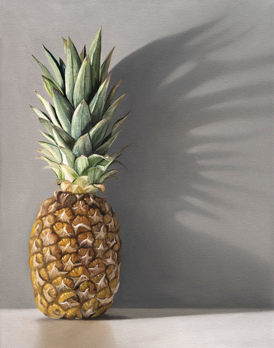 Vibrant pineapple fine art print with green leaves and golden fruit, casting a dramatic shadow on a gray background.