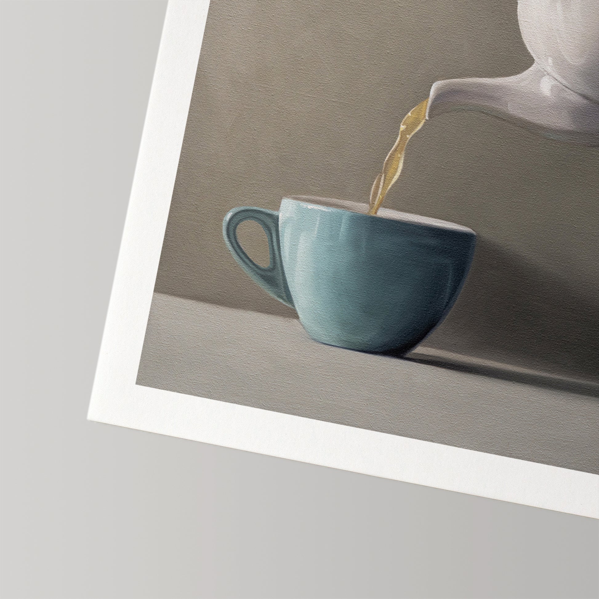 Fine art print of a white teapot pouring golden tea into a light blue cup, with a white border.