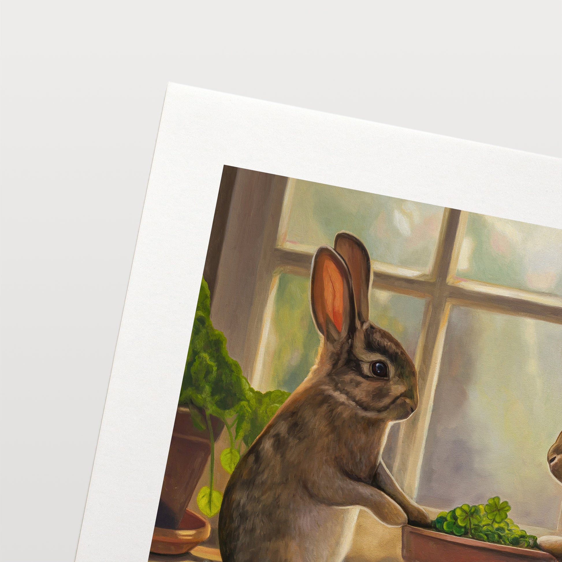 Rabbits & Four Leaf Clovers Fine Art Print by Lauren Pretorius: two rabbits interacting with a potted plant indoors.