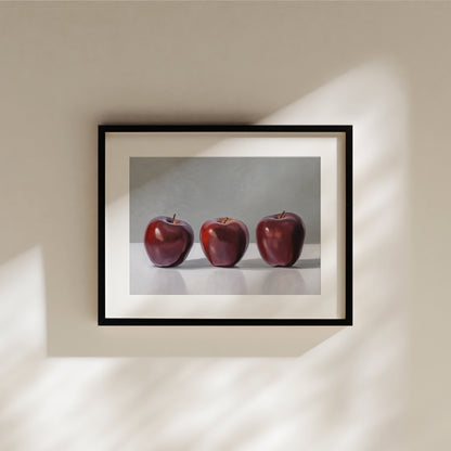 Framed fine art print featuring three vibrant red apples in a realistic, still-life style.
