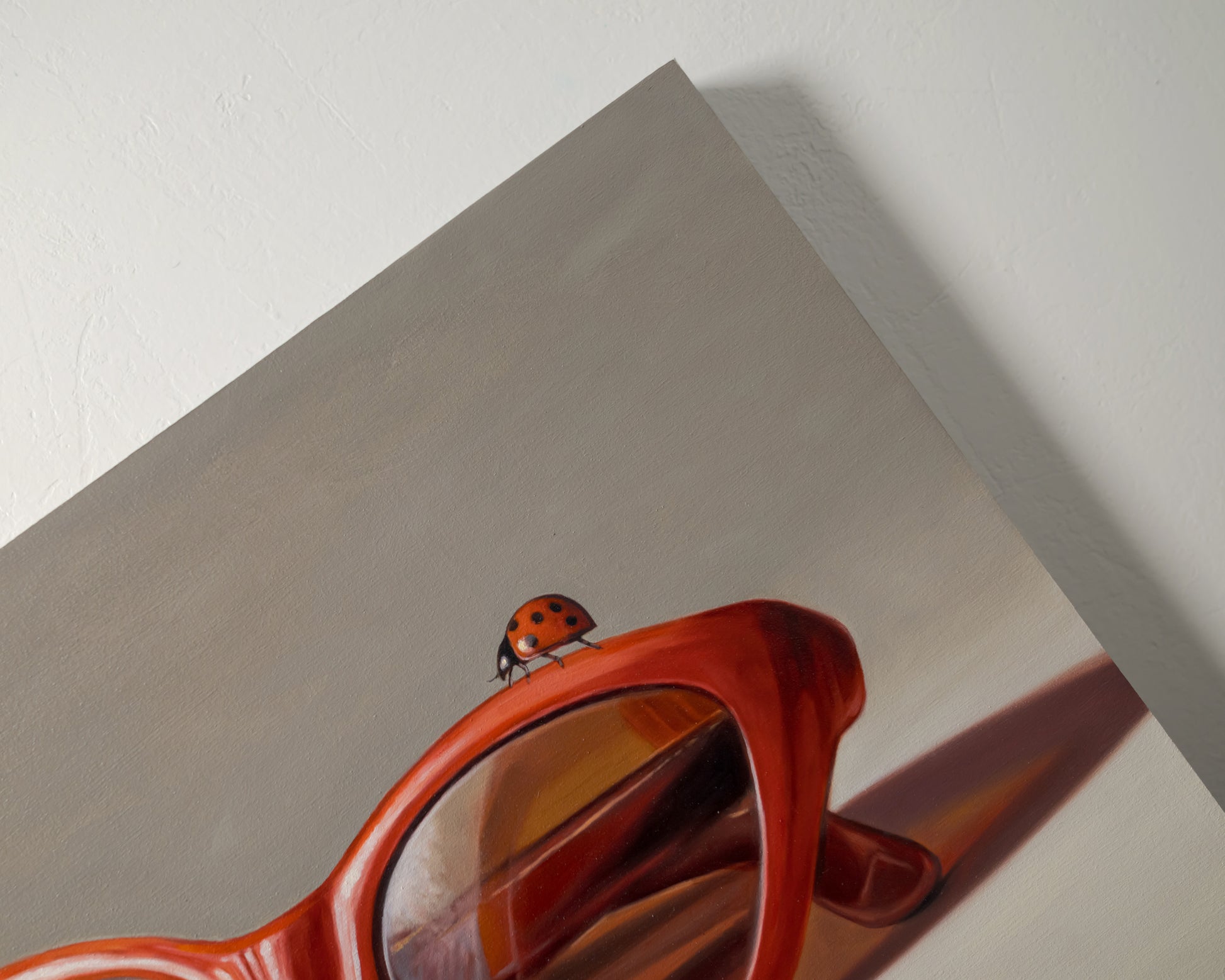 Red Ladies Trio 14" x 11" Original Oil Painting by Lauren Pretorius: red sunglasses with a reflective surface, two ladybugs on and around them against a neutral background.