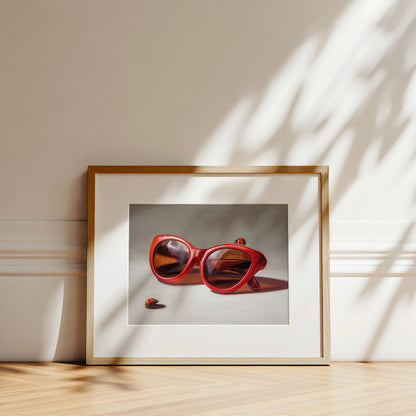 Red Ladies Trio Fine Art Print by Lauren Pretorius: red sunglasses with a reflective surface, two ladybugs on and around them against a neutral background.