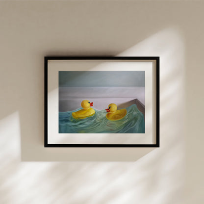 Framed fine art print of two yellow rubber ducks in blue wavy water, with a light background.