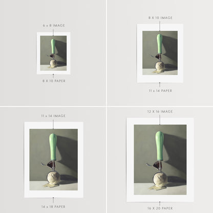 Scoop of Vanilla Fine Art Print by Lauren Pretorius: a vintage ice cream scoop filled with melting vanilla ice cream, set against a softly-lit backdrop of shadows and dramatic lighting.