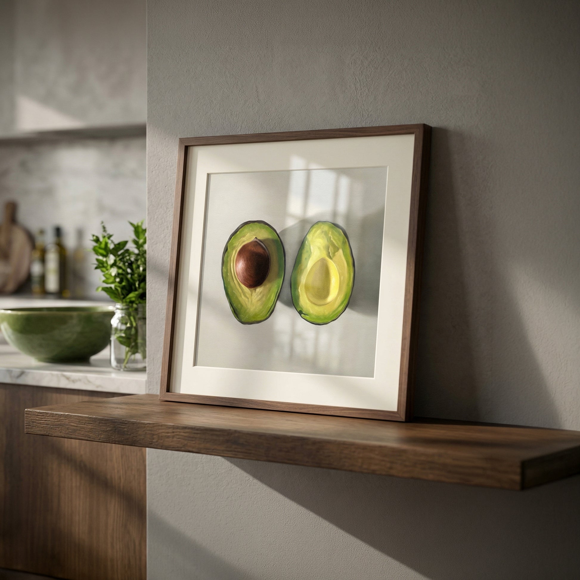 Framed fine art print of two vibrant green avocado halves, one with a brown pit, on a white mat.