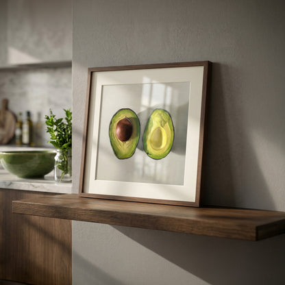 Framed fine art print of two vibrant green avocado halves, one with a brown pit, on a white mat.