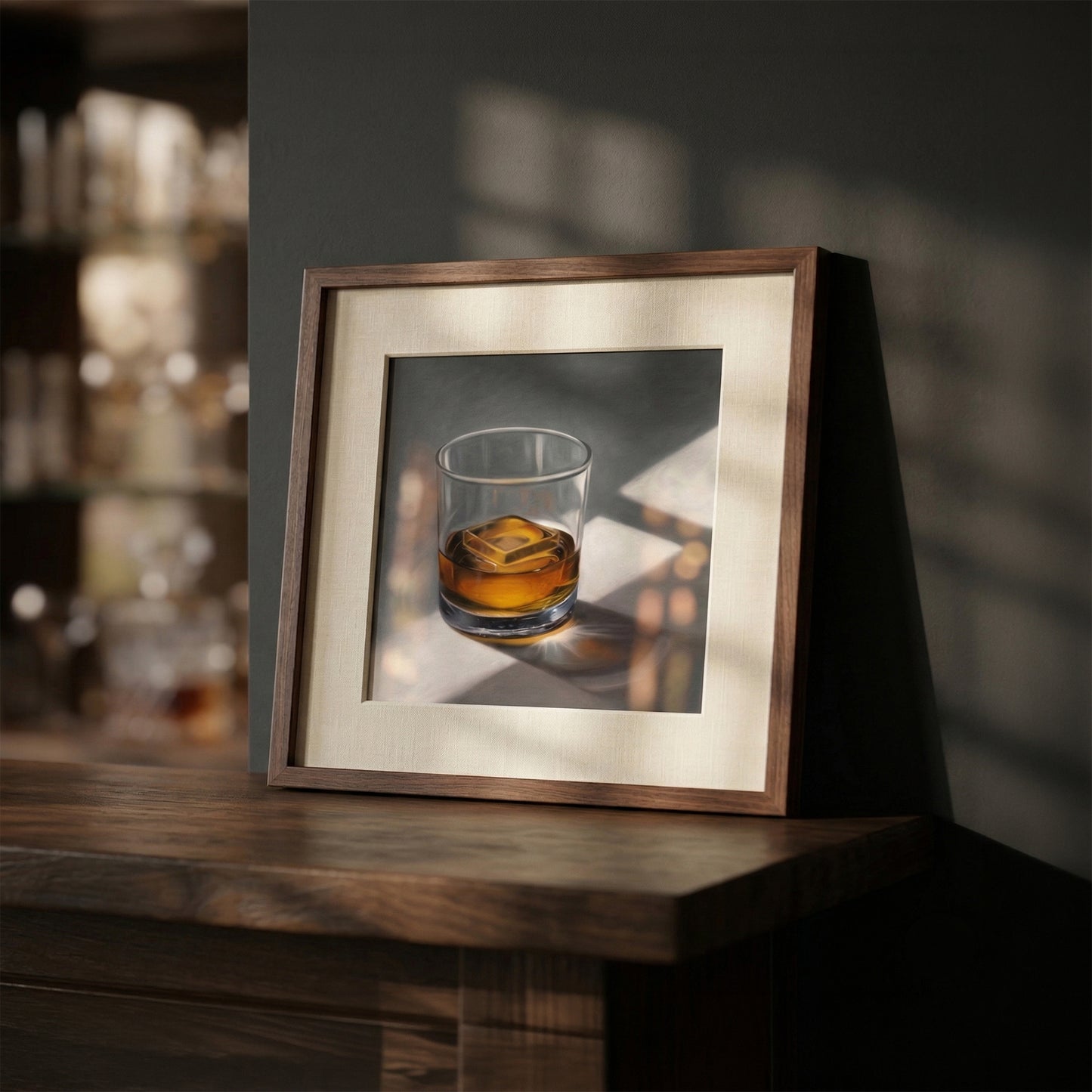 Framed art print of a whiskey glass with ice, featuring warm amber liquid and sunlit shadows on a dark wood surface.