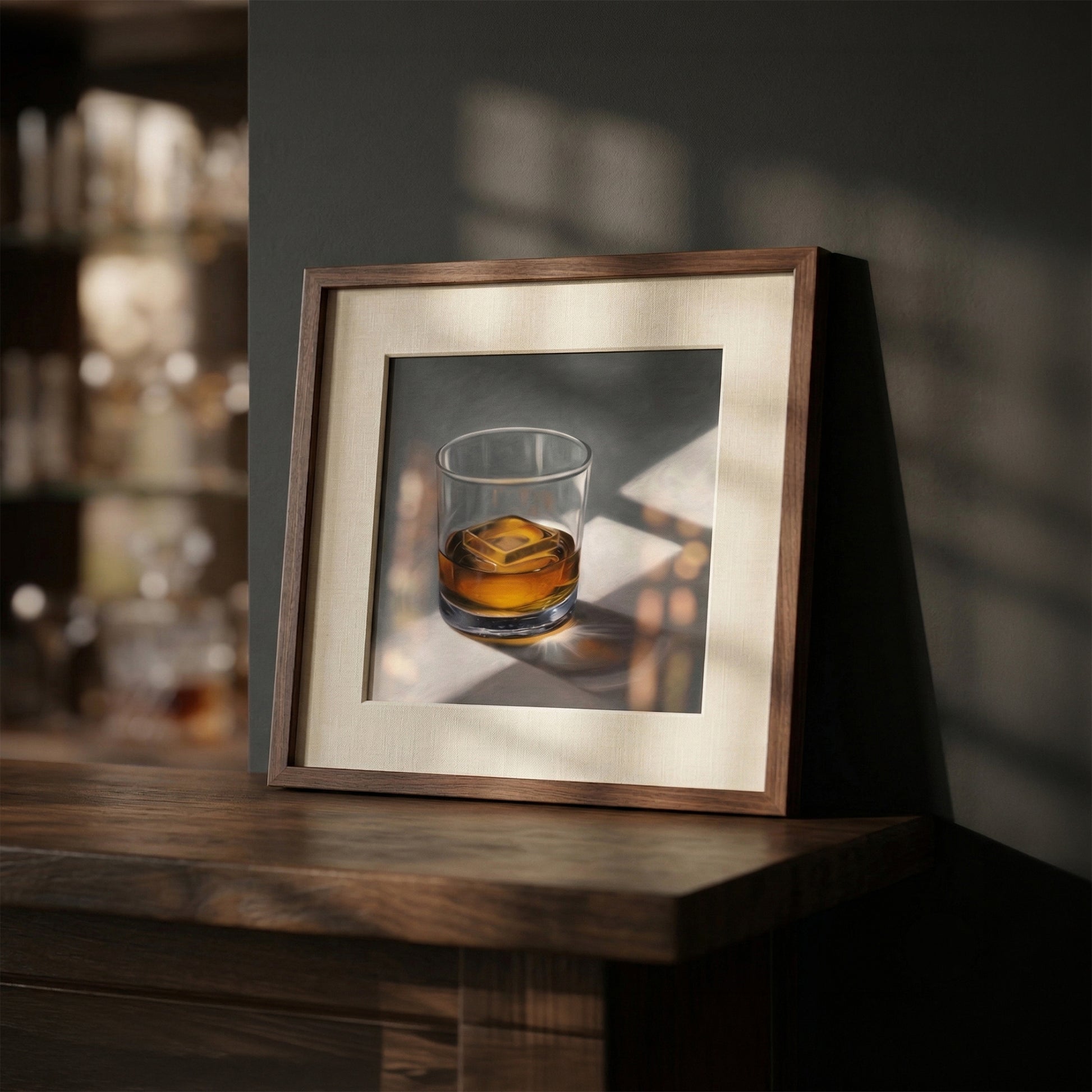 Framed art print of a whiskey glass with ice, featuring warm amber liquid and sunlit shadows on a dark wood surface.
